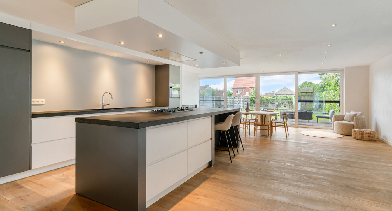 Bij het betreden van de woning wordt u verwelkomd in een verzorgde inkomhal met vestiaire en gastentoilet, die meteen de hoogwaardige afwerking van de woning weerspiegelt. Het gelijkvloers werd doordacht ingericht met een praktische bureauruimte, ideaal v