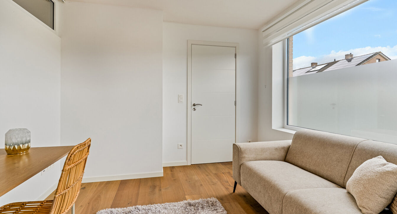 Bij het betreden van de woning wordt u verwelkomd in een verzorgde inkomhal met vestiaire en gastentoilet, die meteen de hoogwaardige afwerking van de woning weerspiegelt. Het gelijkvloers werd doordacht ingericht met een praktische bureauruimte, ideaal v