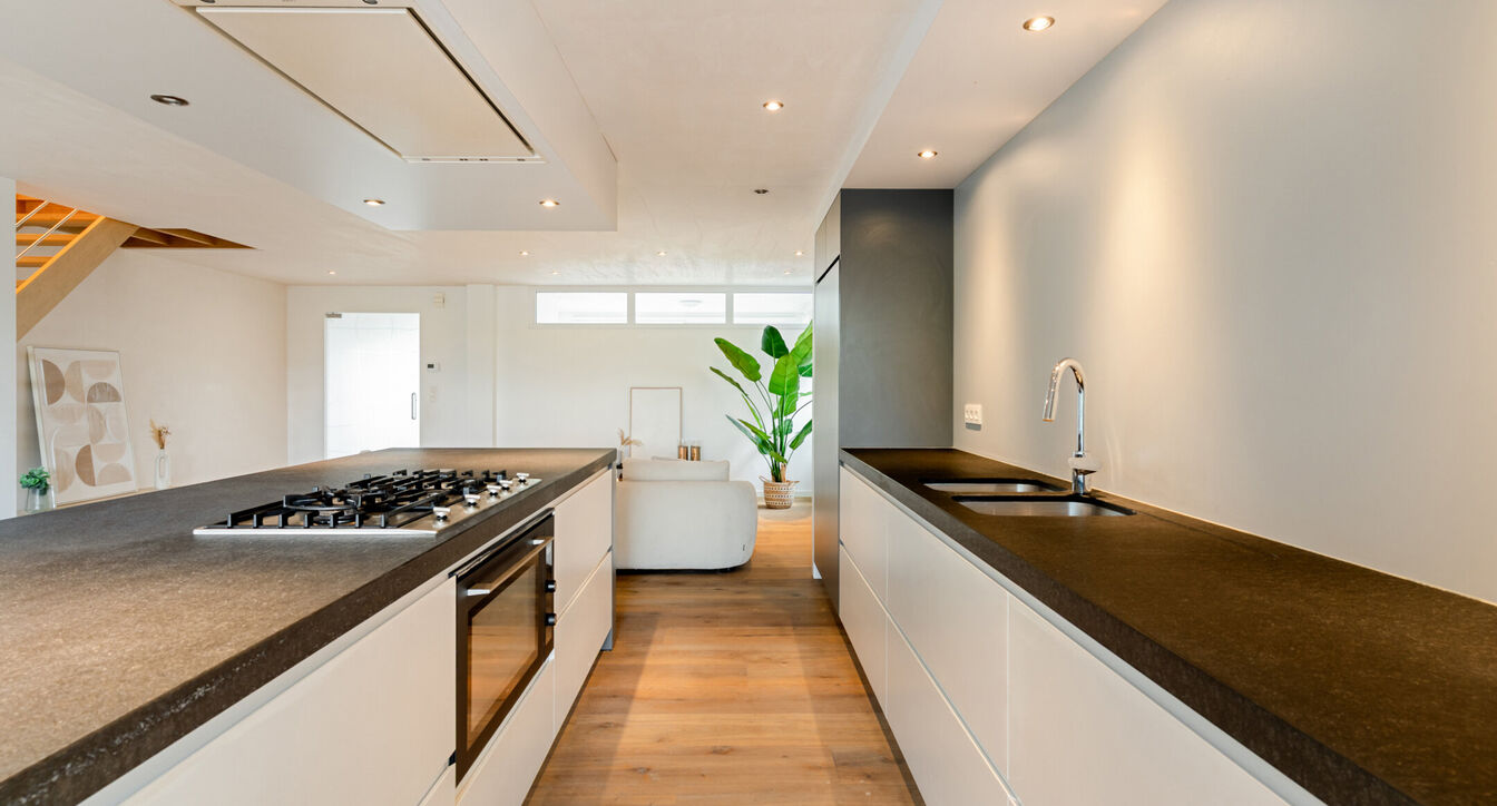 Bij het betreden van de woning wordt u verwelkomd in een verzorgde inkomhal met vestiaire en gastentoilet, die meteen de hoogwaardige afwerking van de woning weerspiegelt. Het gelijkvloers werd doordacht ingericht met een praktische bureauruimte, ideaal v