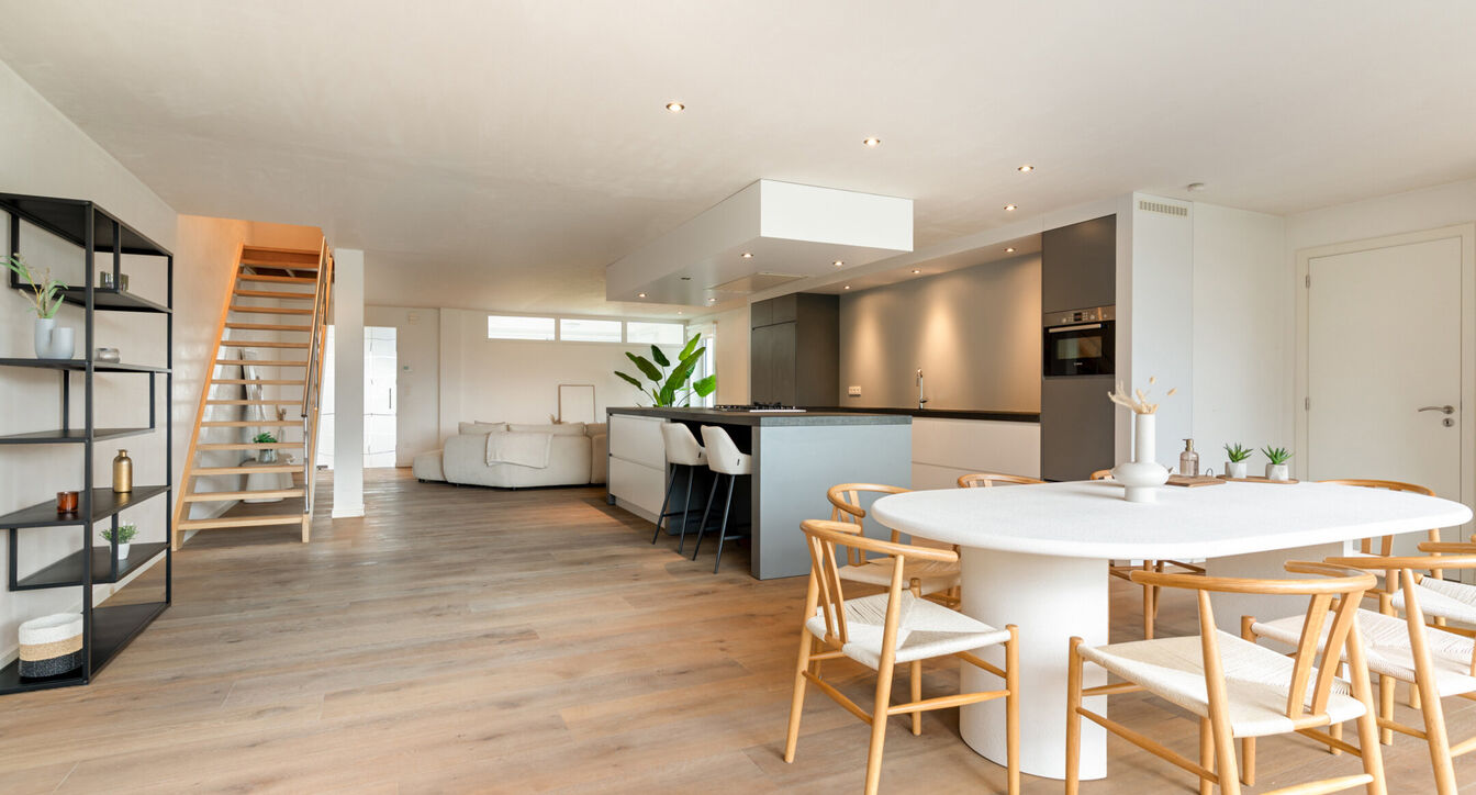 Bij het betreden van de woning wordt u verwelkomd in een verzorgde inkomhal met vestiaire en gastentoilet, die meteen de hoogwaardige afwerking van de woning weerspiegelt. Het gelijkvloers werd doordacht ingericht met een praktische bureauruimte, ideaal v