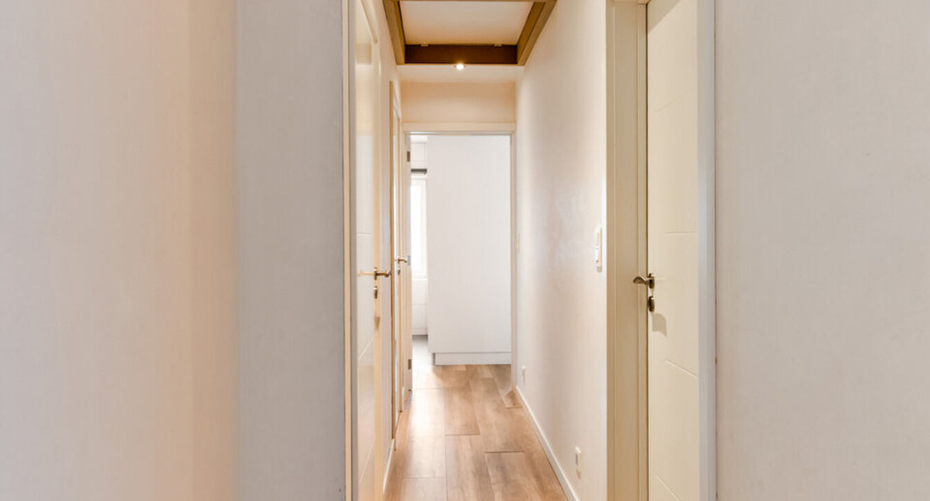 Bij het betreden van de woning wordt u verwelkomd in een verzorgde inkomhal met vestiaire en gastentoilet, die meteen de hoogwaardige afwerking van de woning weerspiegelt. Het gelijkvloers werd doordacht ingericht met een praktische bureauruimte, ideaal v